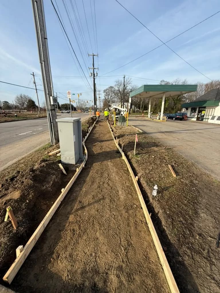 Sidewalk forms set on dirt along a road