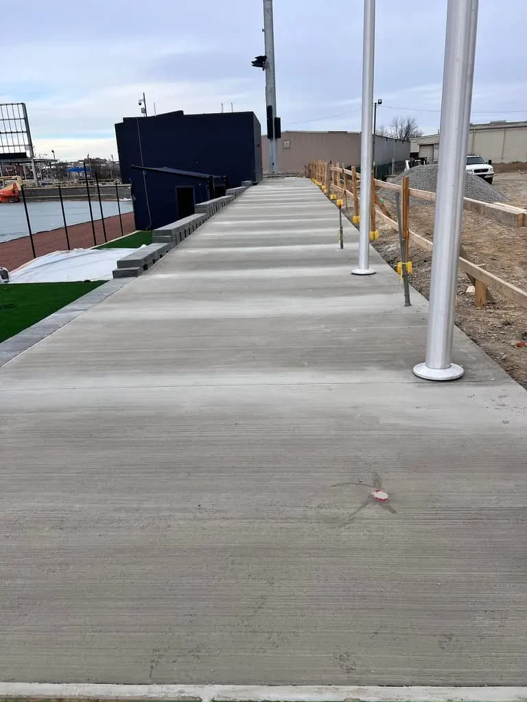 Finished broom-finished concrete walkway by the field